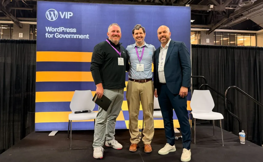 Jake Spurlock, Doug Axelrod, and Andrew Zahn standing together and smiling in front of a "WordPress VIP: WordPress for Government" backdrop after their panel at the Government Service Delivery 2026 conference in Washington, DC.